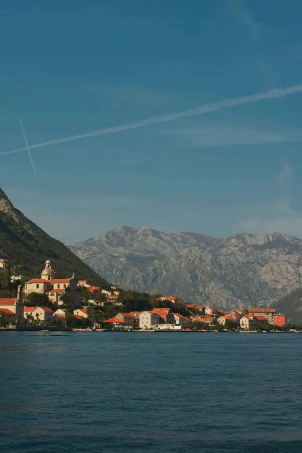 A small town on a bay, mountains behind.