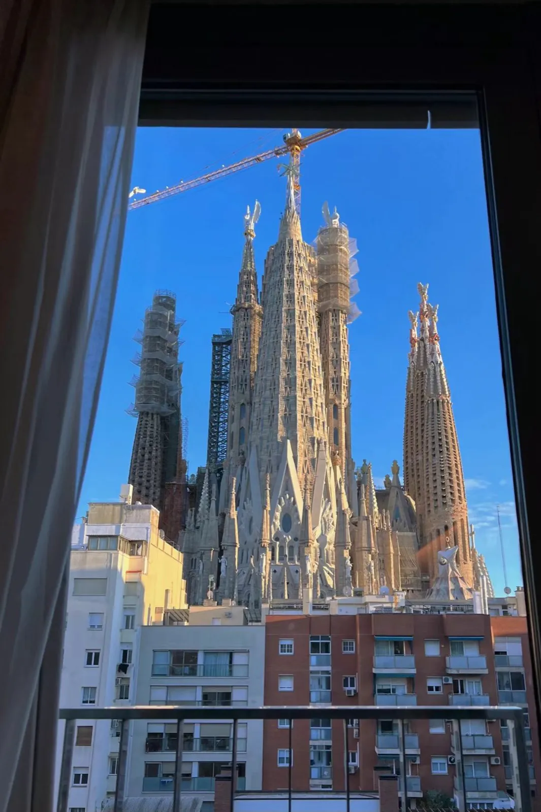 Cathedral spires and cranes through a window.
