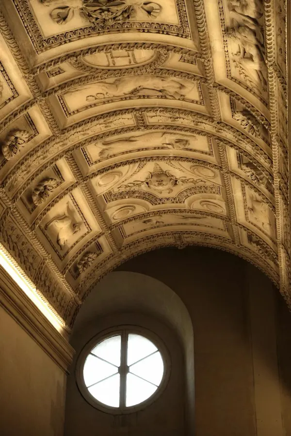 A gilded vaulted ceiling and a round window.