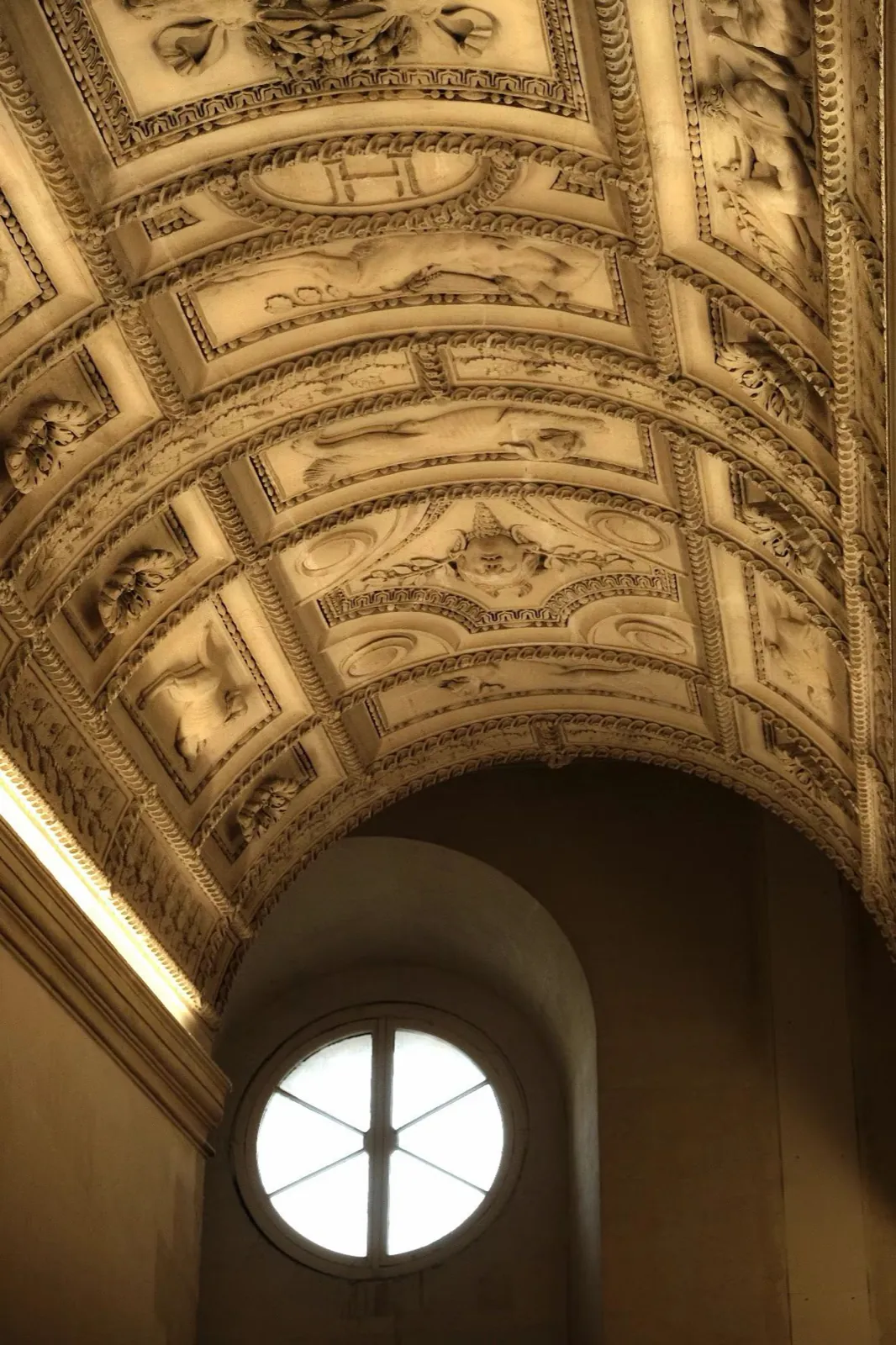 A gilded vaulted ceiling and a round window.