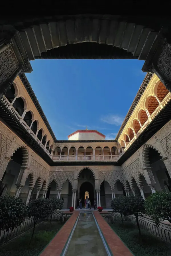 A courtyard of carved arches seen from a doorway.