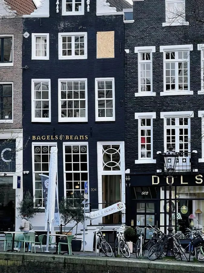 Narrow canal-house facades and bicycles.