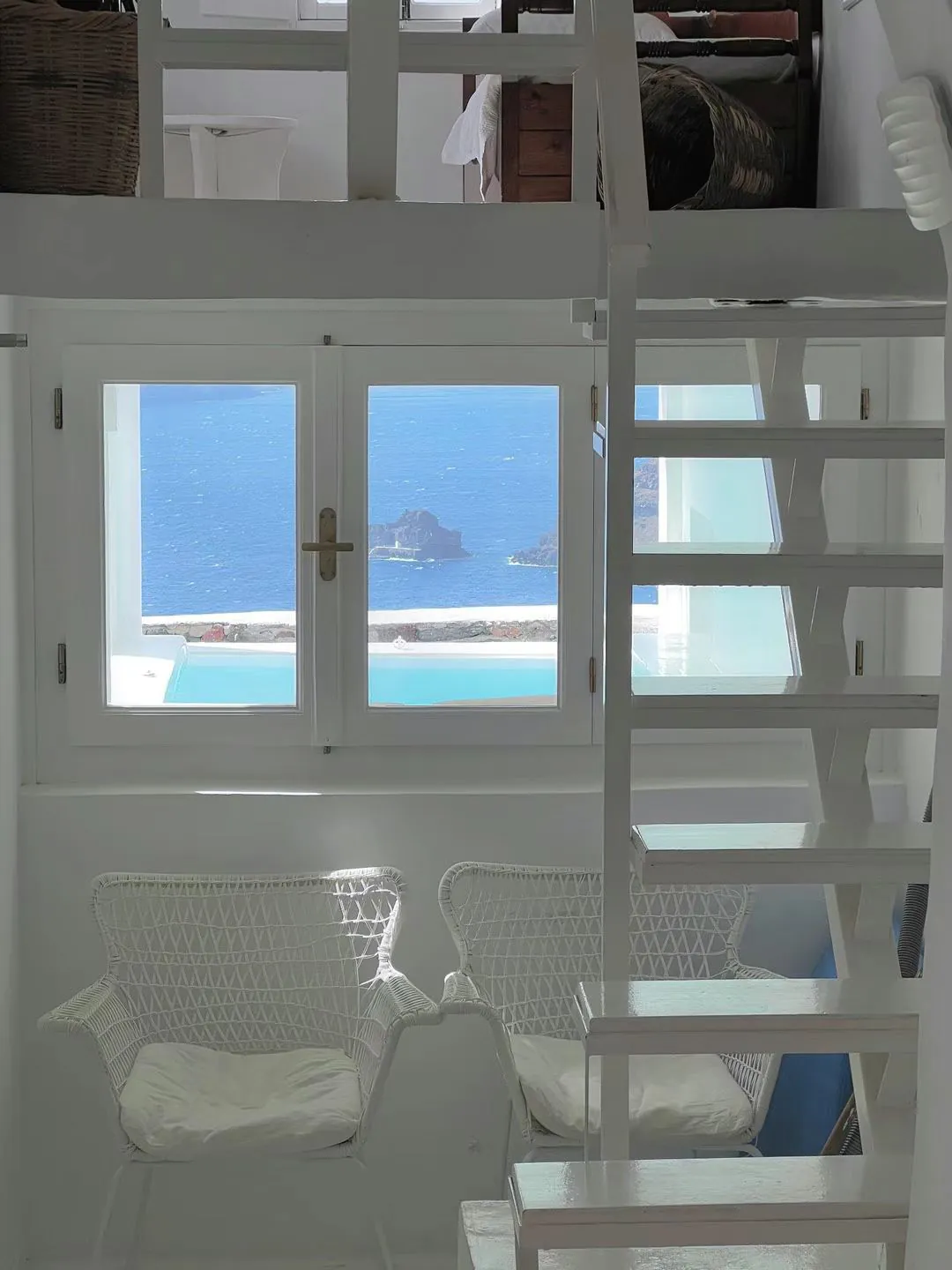 A white room with a window onto the sea.
