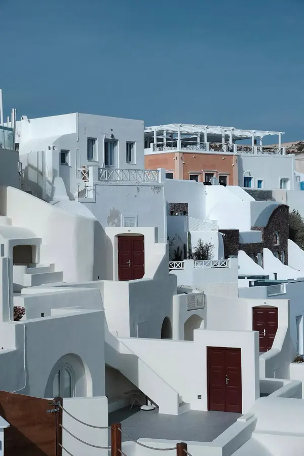 Whitewashed houses stepping down a cliff.