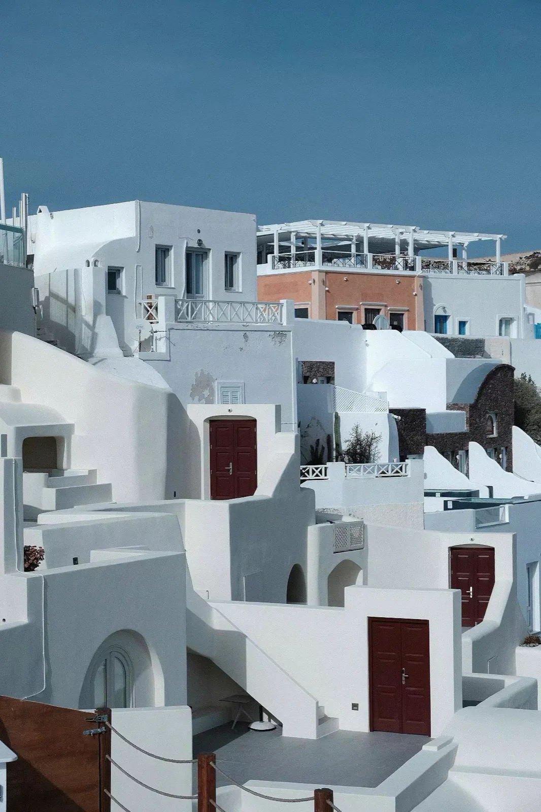 Whitewashed houses stepping down a cliff.