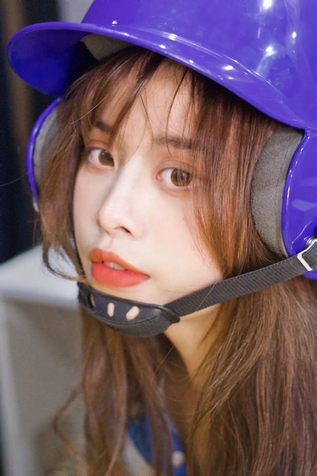 A close portrait under a glossy purple helmet.