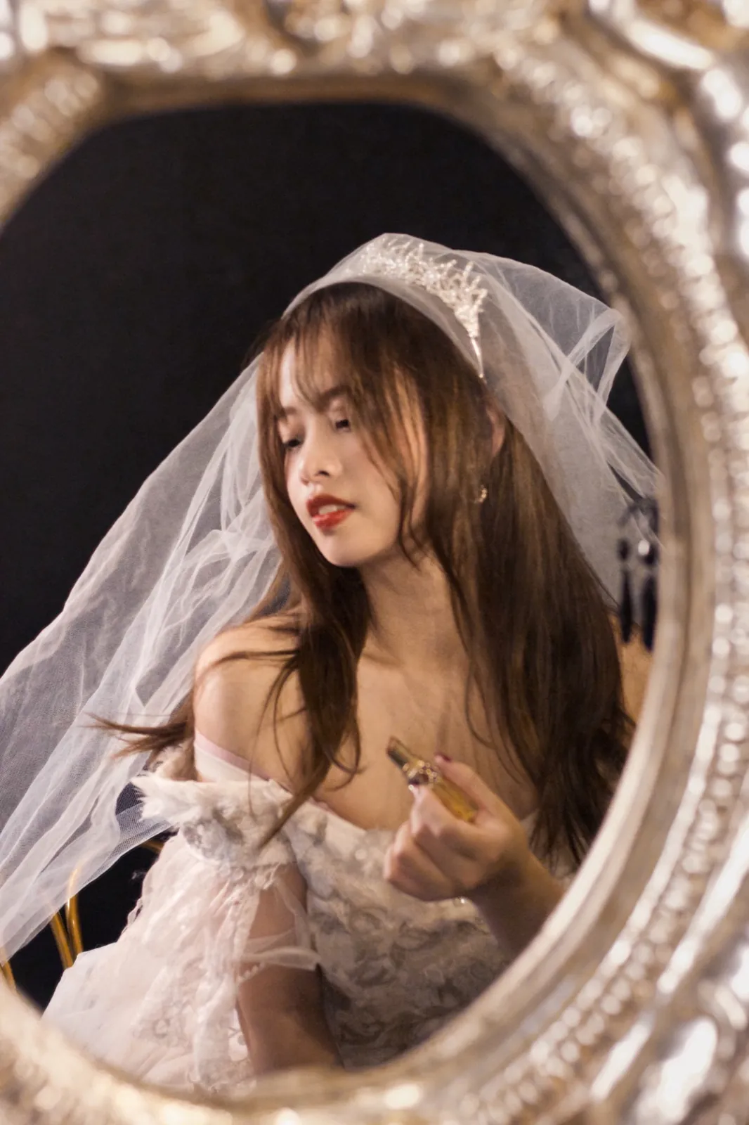 A bride’s veil, seen in an ornate oval mirror.