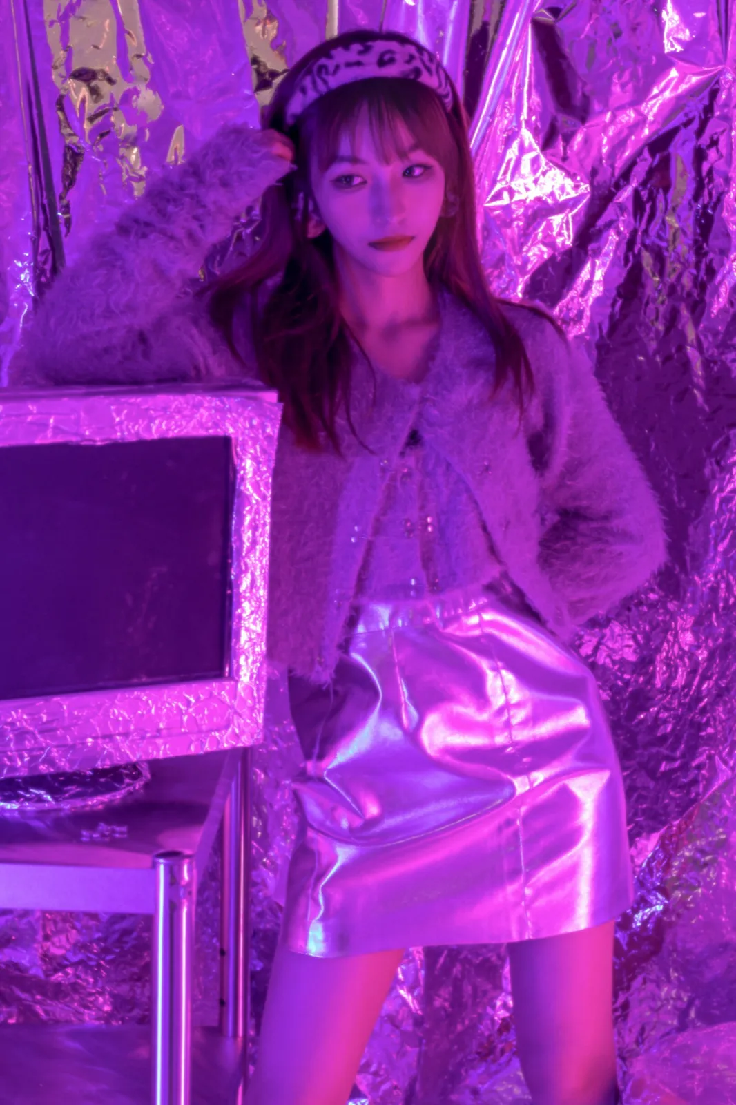 Purple neon on crumpled foil and a fluffy cardigan.
