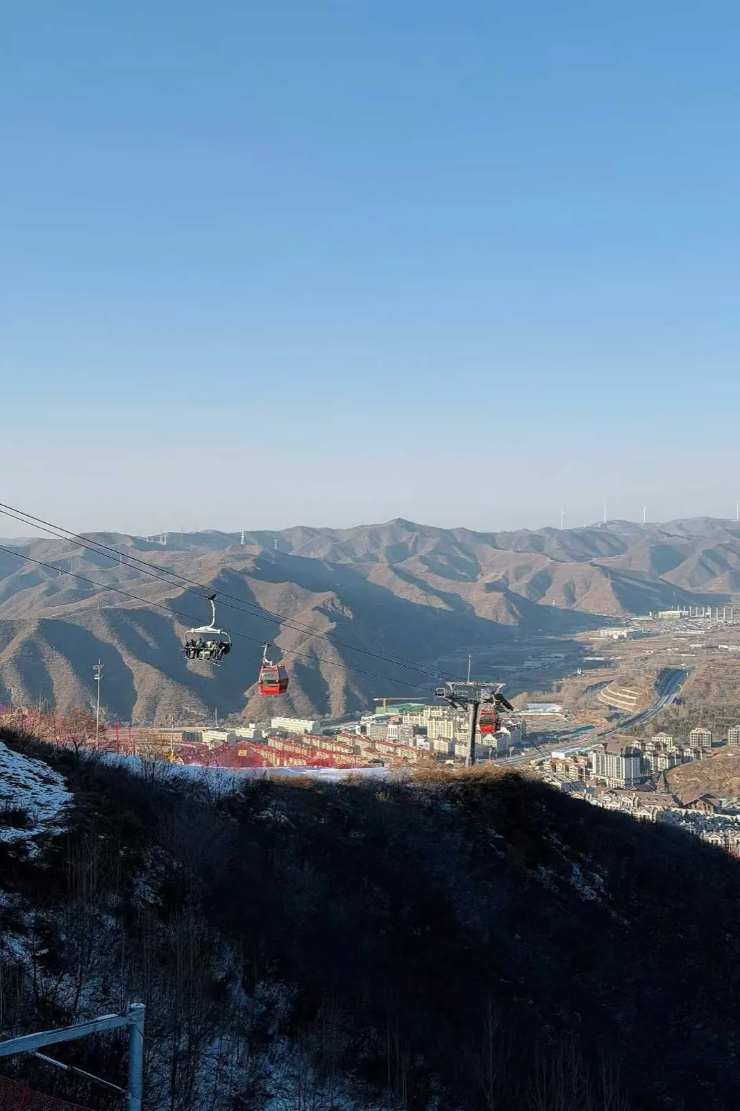 Gondolas over bare mountains, a town far below.