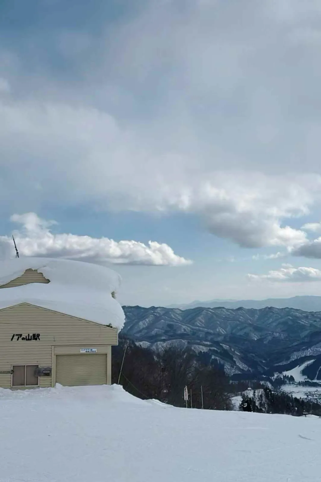 A lift station buried in deep snow, with a Japanese sign.